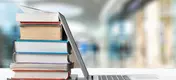laptop leaning on a stack of books